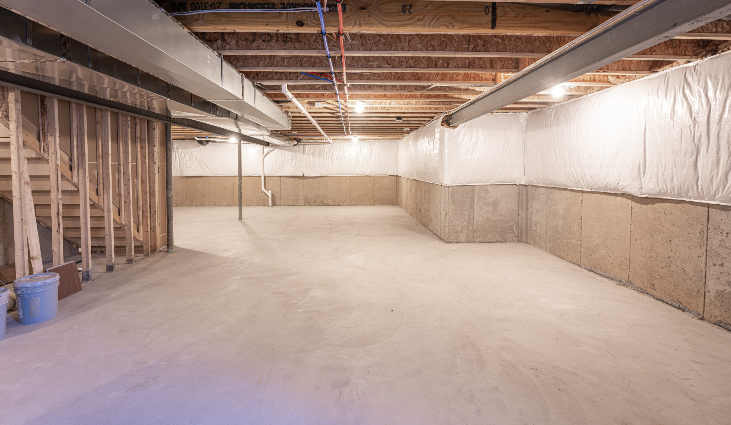 Empty, well-lit basement with concrete walls